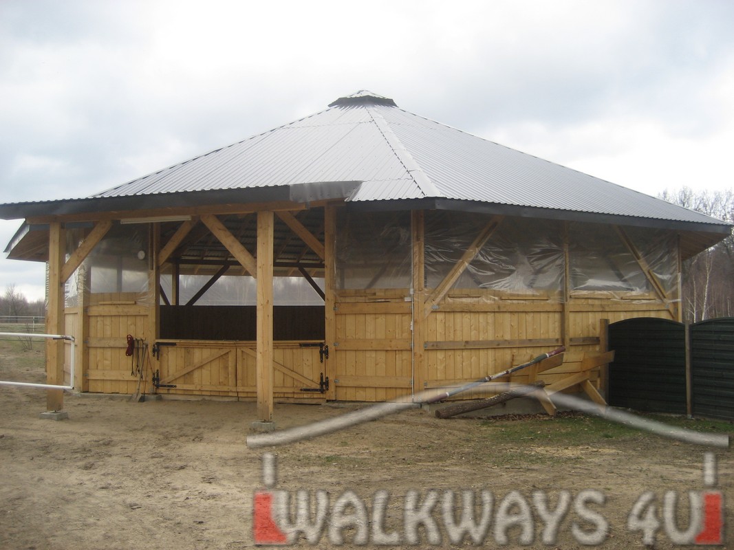 Photo 1. Fully covered lunge pen for lungeing or working horses. The fully covered roof is constructed with laminated wood